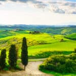 Tuscany, rural sunset landscape. Countryside farm, white road an